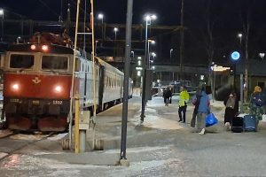 Lok und Wagen im Bahnhof, Dunkelheit, Leute mit Gepäck, Schnee