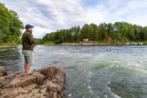Mann mit Angel am Fluss
